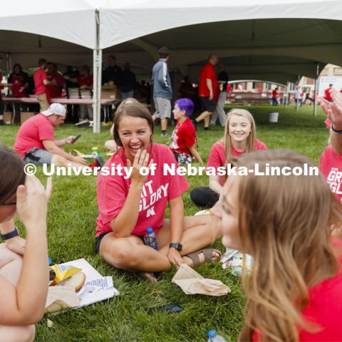 Addison Wittrock of Overland Park, center, and Aubrey Koenig, also of Overland Park, at right, laugh at the story told by their Resident Assistant Rhiannon Cobb. The group lives on Schramm 8. Big Red Welcome, Chancellor's BBQ for incoming freshman and new students on the greenspace by the Memorial Union. August 23, 2019. Photo by Craig Chandler / University Communication.