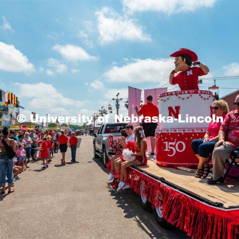 Herbie in cake parade float, flexing for kids in crows. The University of Nebraska represents and celebrates their 150th year anniversary at the Nebraska State Fair in Grand Island, Nebraska. August 1, 2019. Photo by Justin Mohling for University Communication.