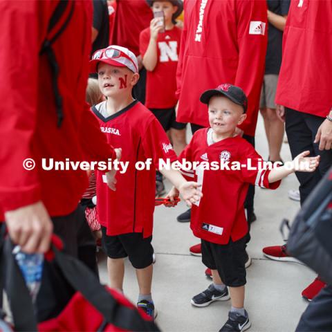 Footbal players high-five young fans as the do the Unity Walk. Nebraska vs. Northern Illinois football game. September 14, 2019. Photo by Craig Chandler / University Communication.