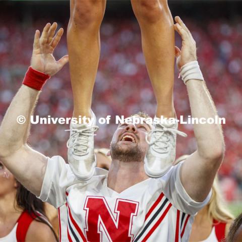 Jake Jundt one of the male cheerleaders assists with a lift at the Nebraska vs. Northern Illinois football game. September 14, 2019. Photo by Craig Chandler / University Communication.