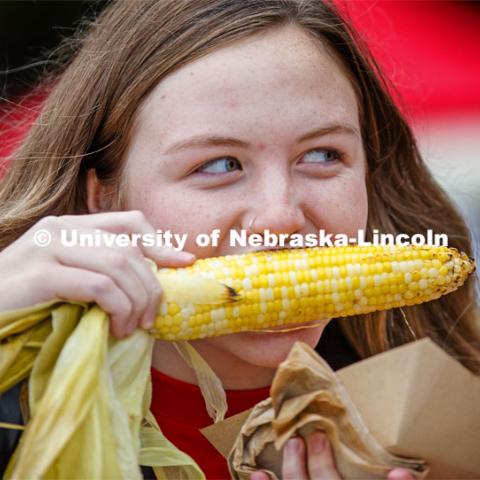 Samantha Simoneau tries an ear of grilled corn. Cornstock celebration and Homecoming Parade. October 4, 2019. Photo by Craig Chandler / University Communication.
