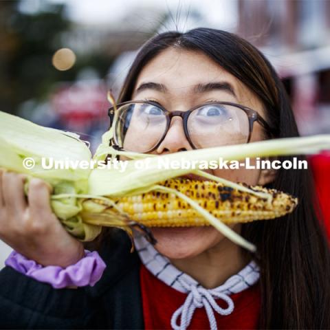 Christine Trinh, freshman from Lincoln, tries an ear of grilled corn. Cornstock celebration and Homecoming Parade. October 4, 2019. Photo by Craig Chandler / University Communication.
