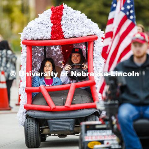 Triad 4's golf cart rolls along the parade route. Triad 4's members are Phi Kappa Psi, Delta Gamma, Pi Kappa Alpha, Tau Kappa Alpha, Tau Kappa Epsilon, Sigma Alllpha, Beta Sigma Psi, Sigma Nu. Cornstock celebration and Homecoming Parade. October 4, 2019. Photo by Craig Chandler / University Communication.