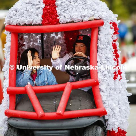 Triad 4's golf cart rolls along the parade route. Triad 4's members are Phi Kappa Psi, Delta Gamma, Pi Kappa Alpha, Tau Kappa Alpha, Tau Kappa Epsilon, Sigma Alllpha, Beta Sigma Psi, Sigma Nu. Cornstock celebration and Homecoming Parade. October 4, 2019. Photo by Craig Chandler / University Communication.