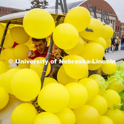 Triad 8's golf cart rolls along the parade route. Triad 8's members are Sigma Chi, Chi Omega, Alpha Chi Omega, Alpha Gamma Sigma, Lambda Phi Epsilon. Cornstock celebration and Homecoming Parade. October 4, 2019. Photo by Craig Chandler / University Communication.