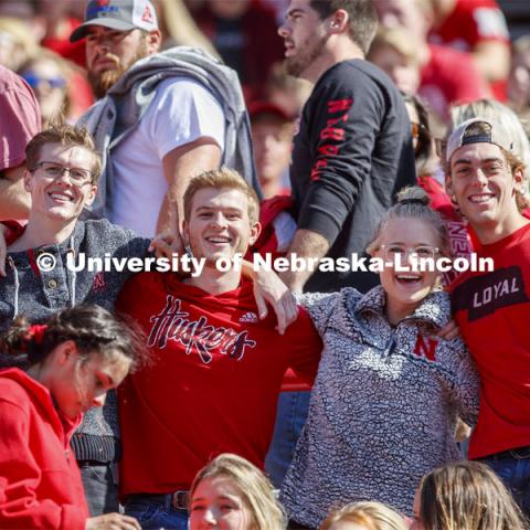 Fans in the student section link arms together and pose for a picture. Nebraska vs. Northwestern University football game. Homecoming 2019. October 5, 2019.  Photo by Craig Chandler / University Communication.