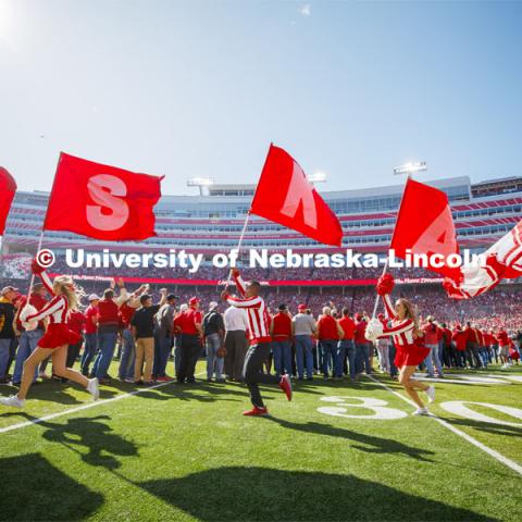 The Cheer Squad run across the field carrying flags that spell NEBRASKA. Nebraska vs. Northwestern University football game. Homecoming 2019. October 5, 2019.  Photo by Craig Chandler / University Communication.