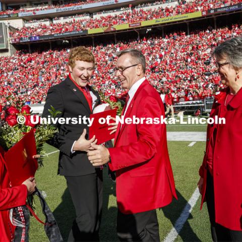 Seniors Cheyenne Gerlach and Bryce Lammers laugh with Chancellor Ronnie Green and Jane, his wife, after the halftime ceremony of the Nebraska-Northwestern football game. Nebraska vs. Northwestern University football game. Homecoming 2019. October 5, 2019.  Photo by Craig Chandler / University Communication.