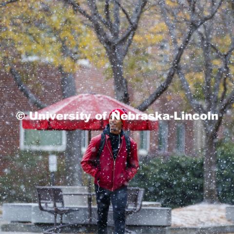 Paul Muragizi, senior in sociology from Lincoln, walks across the plaza during the snow. Snow on campus. October 30, 2019. Photo by Craig Chandler / University Communication.