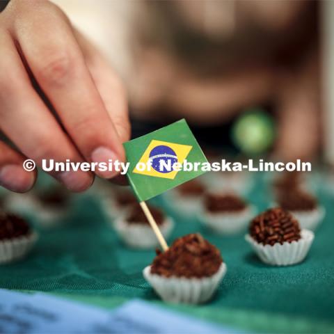 A tiny Brazil flag is inserted into a piece of Brigadeiro, a traditional desert served at every birthday party and made of cocoa powder and condensed milk. Global Huskers Festival, a multicultural festival provides attendees the chance to explore the world through informational booths that will have food, cultural décor, art, and more, each hosted by UNL students from those culture. November 19, 2019. Photo by Craig Chandler / University Communication.