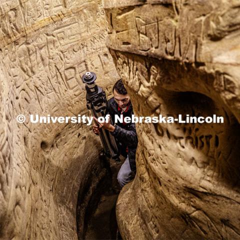 Dylan Downes, a sophomore in civil engineering from Lincoln, carries the tripod through a passage after mapping part of the cave. Professor Ricky Wood uses LIDAR to digitally map Robbers Cave in Lincoln. November 22, 2019. Photo by Craig Chandler / University Communication.