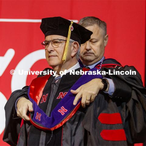 University of Nebraska Regent Robert Schafer places the hood on Mike Johanns.  Johanns was conferred an honorary doctor of laws degree. December Undergraduate commencement at Pinnacle Bank Arena. December 21, 2019. Photo by Craig Chandler / University Communication.