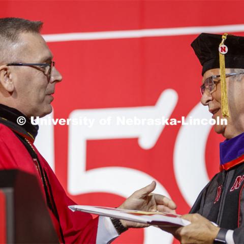 Chancellor Ronnie Green congratulates Mike Johanns after honoring him with an honorary doctor of laws degree. December Undergraduate commencement at Pinnacle Bank Arena. December 21, 2019. Photo by Craig Chandler / University Communication.