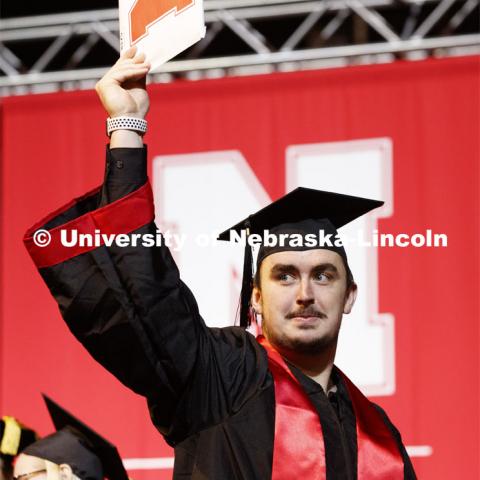 Jackson Walker shows off his college of business diploma to family and friends. December Undergraduate commencement at Pinnacle Bank Arena. December 21, 2019. Photo by Craig Chandler / University Communication.