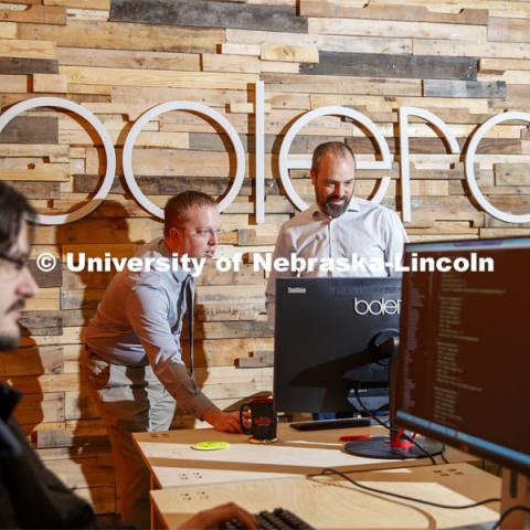Tim Savage and Joel Brehm look over a project as Corey Svehla (foreground) checks coding. NIC partner Bolero is a Midwest web application development and web design company. February 25, 2020. Photo by Craig Chandler / University Communication.