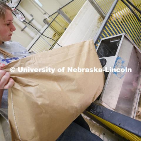 Rylee Kohmetscher, freshman in Animal Science, carries a feed sack for piglets in the Animal Science Building. Students in ASCI 150 - Animal Production Skills. March 12, 2020. Photo by Craig Chandler / University Communication.