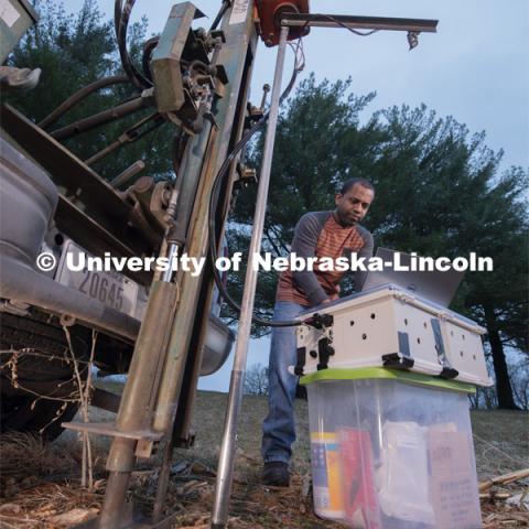 Nuwan Wijewardane, postdoctoral researcher in biological systems engineering, prepares to gather data from multiple locations by hydraulically plunging a penetrometer prototype into soil which is mounted to a Giddings probe truck. March 18, 2020. Photo by Gregory Nathan / University Communication.
