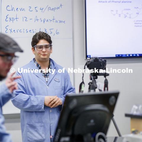 Saman Bagheri watches as Elijah Stowe counts down to the start of his recorded lab talk as he and Richard Hartung, right, record an organic chemistry lab. As a result of the Corona virus, Faculty are recording Chemistry labs in Hamilton Hall to prepare for the start of remote learning. March 24, 2020. Photo by Craig Chandler / University Communication.