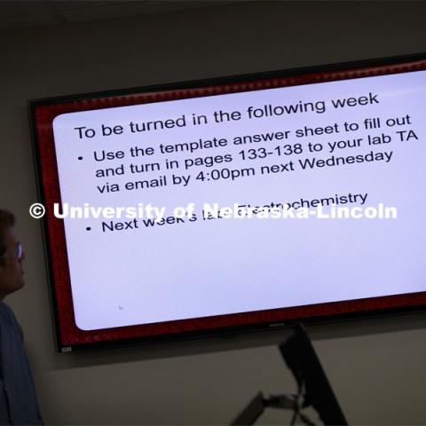 Bailey McLean, junior in biological sciences, watches a PowerPoint slide as he helps with the recording of a Chem 110 lab on entropy and spontaneity. As a result of the Corona virus, Faculty are recording Chemistry labs in Hamilton Hall to prepare for the start of remote learning. March 24, 2020. Photo by Craig Chandler / University Communication.