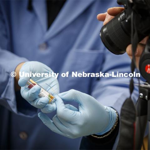 A litmus strip which shows the ph balance for the solution is shown to the camera during a chemistry lab recording. As a result of the Corona virus, Faculty are recording Chemistry labs in Hamilton Hall to prepare for the start of remote learning. March 24, 2020. Photo by Craig Chandler / University Communication.