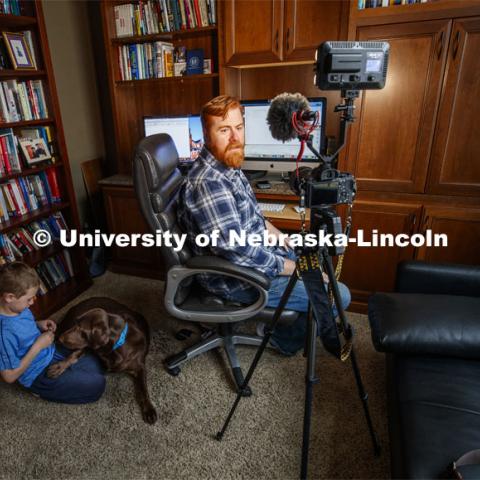 Tyler White records a lecture in his home office while his son, Gavin, 7, plays with their dog Ripley. White, Associate Professor of Practice, Political Science, was recording the lecture for his course, National Security Studies 475 - Threats and Solutions to Global Security in the 21st Century. Tyler is teaching remotely from home due to the COVID-19 virus impact on campus. March 26, 2020. Photo by Craig Chandler / University Communication.