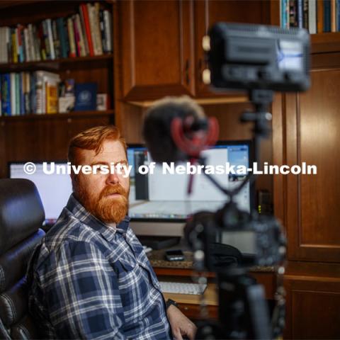 Tyler White records a lecture in his home office while his son, Gavin, 7, plays with their dog Ripley. White, Associate Professor of Practice, Political Science, was recording the lecture for his course, National Security Studies 475 - Threats and Solutions to Global Security in the 21st Century. Tyler is teaching remotely from home due to the COVID-19 virus impact on campus. March 26, 2020. Photo by Craig Chandler / University Communication.