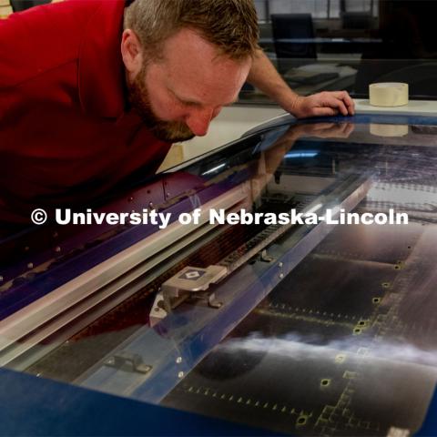 Jerry Reif, shop manager at Nebraska Innovation Studio, works on a laser to cut clear plastic sheeting for face shields. The face shields are being assembled for hospitals in Nebraska in response to COVID-19. April 1, 2020. Photo by Gregory Nathan / University Communication.