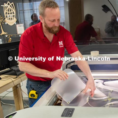 Jerry Reif, shop manager at Nebraska Innovation Studio, works on a laser to cut clear plastic sheeting for face shields. The face shields are being assembled for hospitals in Nebraska in response to COVID-19. April 1, 2020. Photo by Gregory Nathan / University Communication.