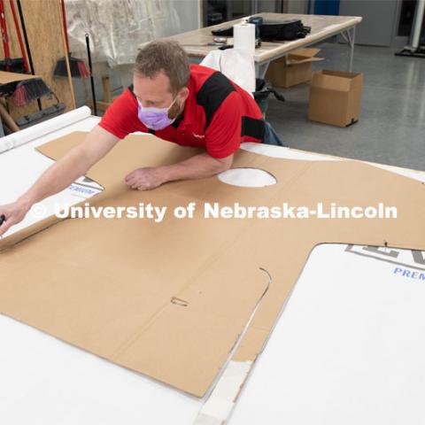 Jerry Reif, shop manager at Nebraska Innovation Studio, cuts hospital gowns from Tyvec material house wrap. The gowns are being assembled for hospitals in Nebraska in response to COVID-19. April 9, 2020. Photo by Gregory Nathan / University Communication.