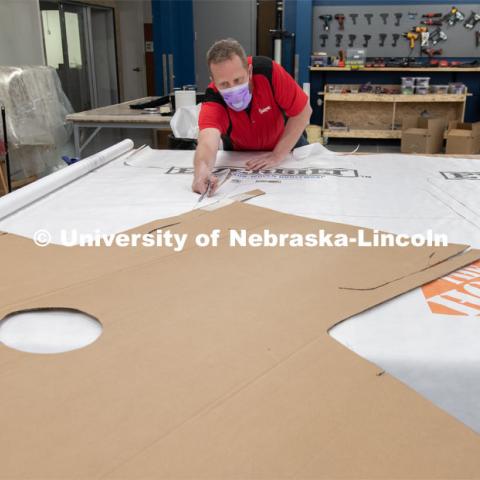 Jerry Reif, shop manager at Nebraska Innovation Studio, cuts hospital gowns from Tyvec material house wrap. The gowns are being assembled for hospitals in Nebraska in response to COVID-19. April 9, 2020. Photo by Gregory Nathan / University Communication.