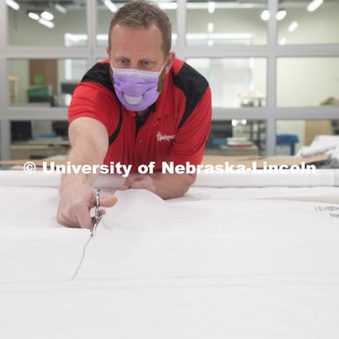 Jerry Reif, shop manager at Nebraska Innovation Studio, cuts hospital gowns from Tyvec material house wrap. The gowns are being assembled for hospitals in Nebraska in response to COVID-19. April 9, 2020. Photo by Gregory Nathan / University Communication.