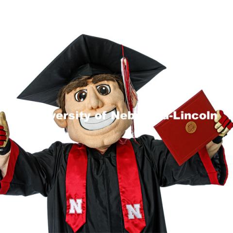 Herbie Husker proudly holds a diploma and is decked out in graduation attire for the Spring Commencement that was which streamed online and aired on NET because of the COVID-19 pandemic. April 10, 2020. Photo by Craig Chandler / University Communication.