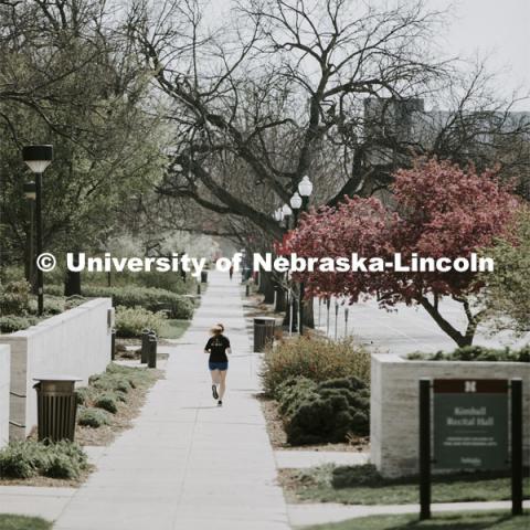 A young woman jogs across City Campus, which is empty, due to COVID-19. April 22, 2020. Photo by Craig Chandler / University Communication.
