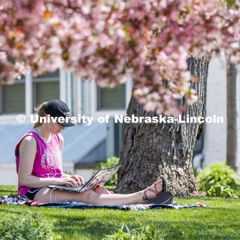 Kelsey Eihausen, sophomore from Bennington, studies outside of the Phi Mu sorority. She and other members staying in the chapter house study outside on a spring day. April 28, 2020. Photo by Craig Chandler / University Communication.