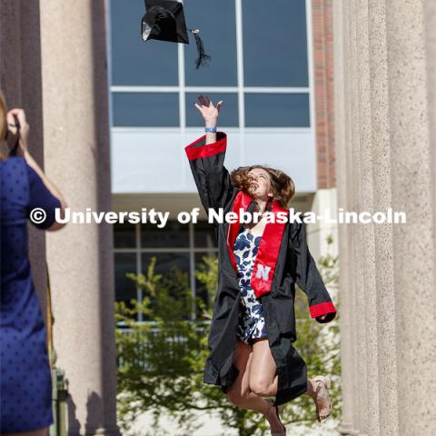 Sarah Schilling, senior in marketing from Omaha, is photographed by Rose Wehrman, senior in English, from Kenesaw, NE. The two borrowed a cap and gown (from a friend who graduated last year) to take photos of each other on campus Thursday morning. April 30, 2020. Photo by Craig Chandler / University Communication.