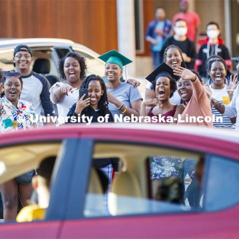 Rwandan graduates and undergraduates wave to the parade as it circles University Suites Friday evening. Christ Place Church families gave the Rwandan students a vehicle parade to help celebrate the graduates and undergraduates. The church has been host families for about 25 of the 50 Rwandan students who are graduating. They also provided fall and spring event off-campus marking the beginning and ending of each school year along with rides from campus to church and back each Sunday. The group of host families had been planning a graduation party for the students until COVID-19 occurred. Because of COVID-19, the group has planned for a socially distanced “parade” of host family vehicles that circled University Suites on R Street. May 8, 2020. Photo by Craig Chandler / University Communication.