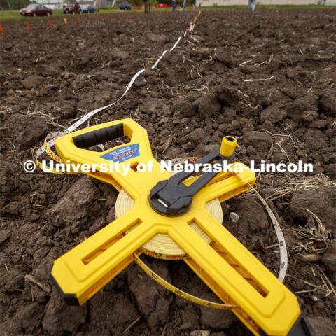 Tape measures are used to keep the row spacing accurate. James Schnable's group hand plants corn and sorghum seeds at the East Campus ag fields. May 20, 2020. Photo by Craig Chandler / University Communication.