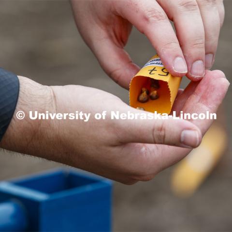 James Schnable pours corn kernels into his hand for the next row of planting. East Campus ag fields. May 20, 2020. Photo by Craig Chandler / University Communication.