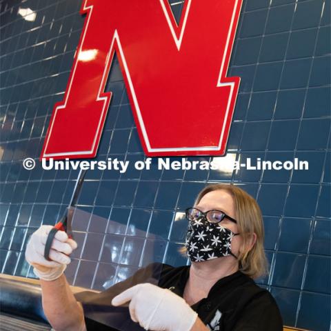 Dinning Services employees, Rochan Pinho, Janet Nichols and Dami Olsen, assemble face shields at Harper Dining Center. Once school starts up, they will use the shields for prevention of the spread of COVID-19. April 28, 2020. Photo by Gregory Nathan / University Communication.