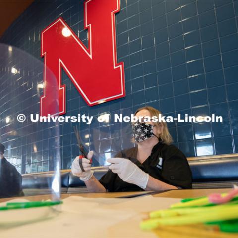 Dinning Services employees, Rochan Pinho, Janet Nichols and Dami Olsen, assemble face shields at Harper Dining Center. Once school starts up, they will use the shields for prevention of the spread of COVID-19. April 28, 2020. Photo by Gregory Nathan / University Communication.