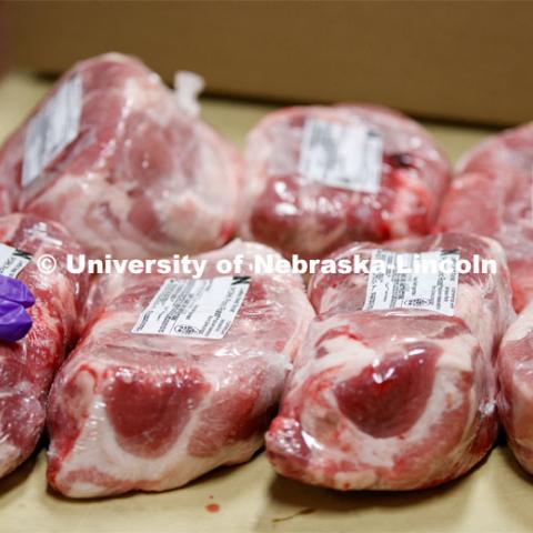 Labels are added to shrink-wrapped Pork Picnic Roast. UNL's Loeffel Meat Laboratory in partnership with the Nebraska Pork Producers Association Pork Cares program process more than 1500 pounds of pork for the Food Bank for the Heartland in Omaha. This is the second donation being processed for food banks. Friends and family of Bill and Nancy Luckey of Columbus donated the pigs. The first donation went to the Lincoln Food Bank. The pigs were harvested and processed at the east campus meat lab. May 28, 2020. Photo by Craig Chandler / University Communication.