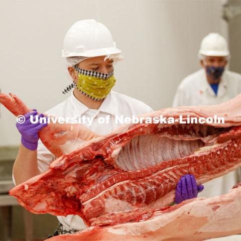 David Velazco, a masters student in Animal Science, positions a pork carcass onto the cutting table in the meat lab Thursday. UNL's Loeffel Meat Laboratory in partnership with the Nebraska Pork Producers Association Pork Cares program process more than 1500 pounds of pork for the Food Bank for the Heartland in Omaha. This is the second donation being processed for food banks. The first donation went to the Lincoln Food Bank. Friends and family of Bill and Nancy Luckey of Columbus donated the pigs. The pigs were harvested and processed at the east campus meat lab. May 28, 2020. Photo by Craig Chandler / University Communication.