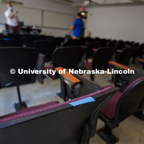 Jack Dohrman, Interim University Space Manager, with Facilities Management and Planning, and Shawn Languis, Space Planning/GIS Data Coordinator with Facilities Management and Planning, measure physical possibilities for 6-foot social distancing in an Avery Hall classroom. This classroom will go from 35 seats to at most 14 seats. A group is physically measuring every classroom on campus to see if computer-aided predictions are correct. June 1, 2020. Photo by Craig Chandler / University Communication.