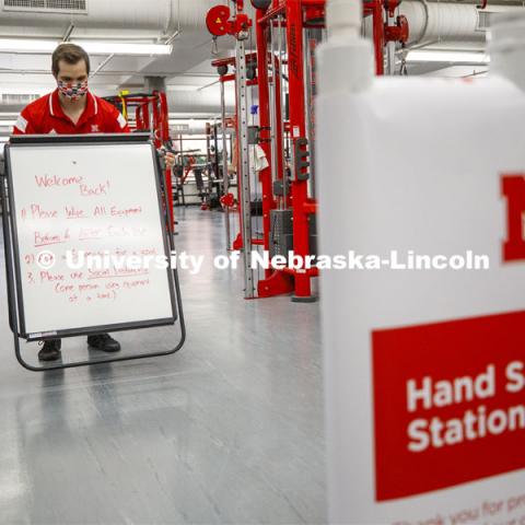 Josh Bruno, strength and conditioning coach, places a sign at the entrance to the weight room. First day of Campus Recreation re-opening after being shut down due to COVID-19 concerns. June 15, 2020. Photo by Craig Chandler / University Communication.