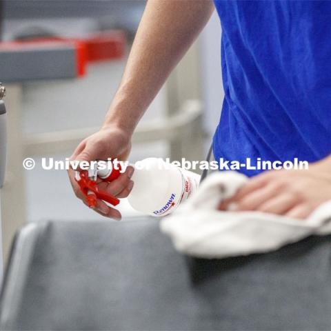 A student disinfects a weight station following his workout. First day of Campus Recreation re-opening after being shut down due to COVID-19 concerns. June 15, 2020. Photo by Craig Chandler / University Communication.