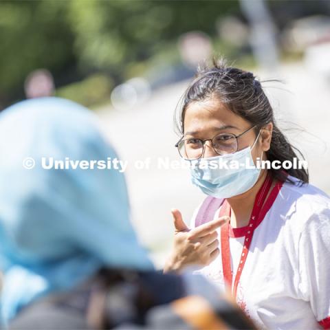 Sandhya Karki wears a mask while talking with a friend. Photo shoot of students wearing masks and practicing social distancing. June 24, 2020. Photo by Craig Chandler / University Communication.