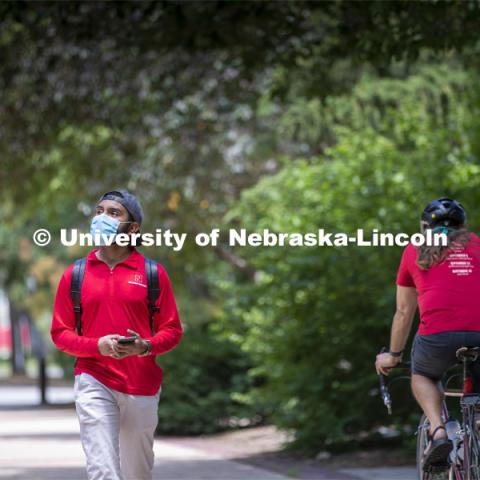 Aldi Airori walks across campus wearing his mask. Photo shoot of students wearing masks and practicing social distancing. June 24, 2020. Photo by Craig Chandler / University Communication.