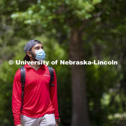 Aldi Airori walks across campus wearing his mask. Photo shoot of students wearing masks and practicing social distancing. June 24, 2020. Photo by Craig Chandler / University Communication.