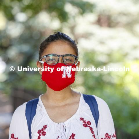 Esha Mishra, graduate student in physics, models the new N mask. More than 60,000 face masks are to be distributed to all students, faculty and staff for the fall semester. June 26, 2020. Photo by Craig Chandler / University Communication.