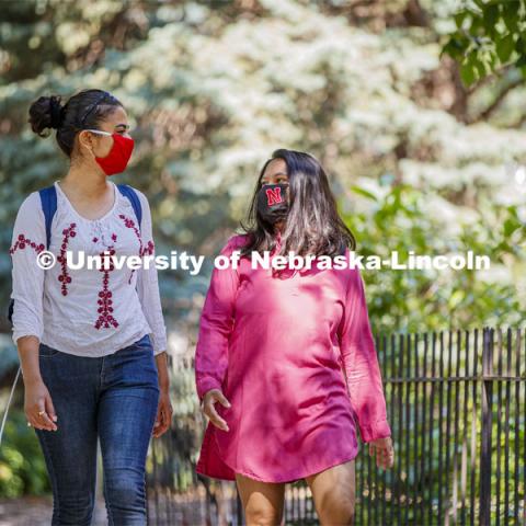 Asmita Jayswal, junior in computer science, and Esha Mishra, graduate student in physics, walk along R Street wearing the new N mask. More than 60,000 face masks are to be distributed to all students, faculty and staff for the fall semester. June 26, 2020. Photo by Craig Chandler / University Communication.